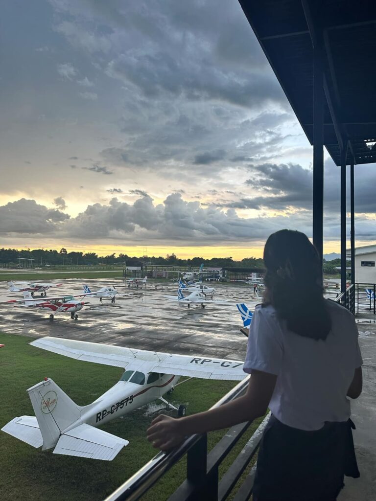 Aspiring commercial pilot standing on a runway apron looking toward the airstrip, representing pilot career opportunities in Nepal