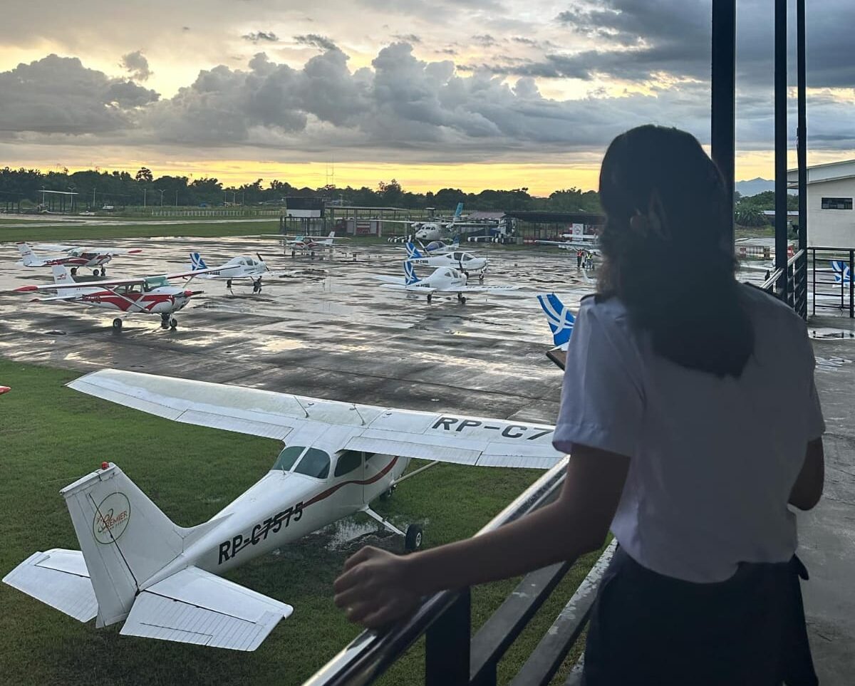 Aspiring commercial pilot standing on a runway apron looking toward the airstrip, representing pilot career opportunities in Nepal