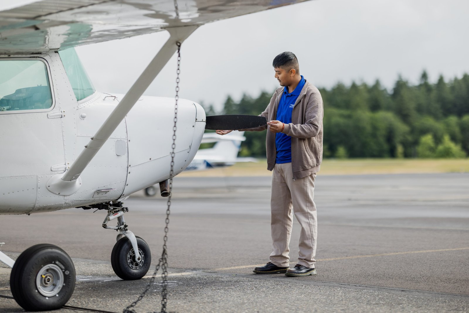 Nepali student pilot carrying out a pre-flight propeller inspection on a single-engine training aircraft at Hillsboro Aero Academy for the Airplane CPL Nepal programme, USA